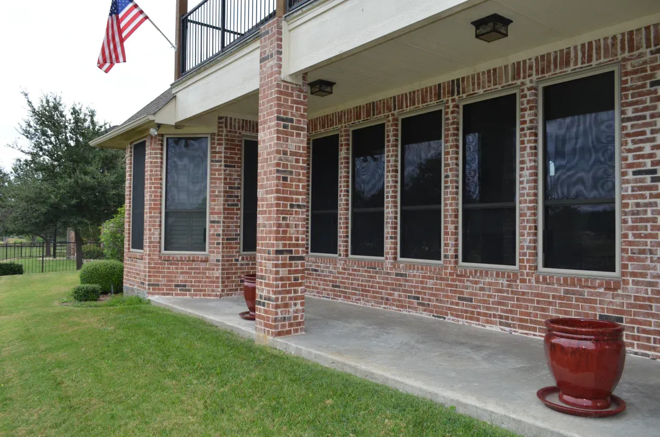 A large brick house with a flag on the porch