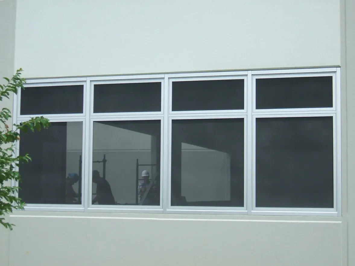 A white building with a large window with black screens