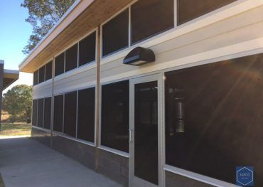 A building with screened in windows and a door.