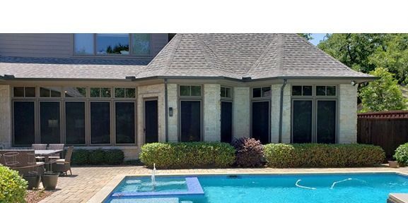 A large house with a swimming pool in front of it