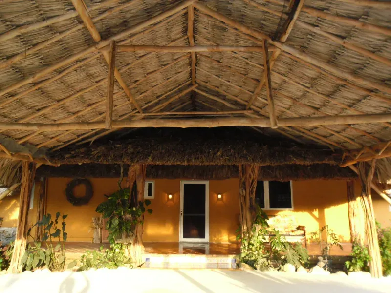 A house with a thatched roof and a wreath on the door