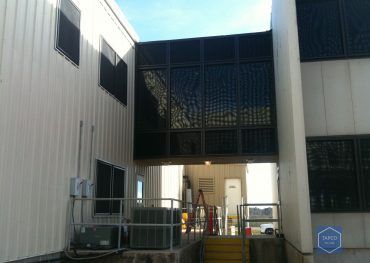 There is a bridge between two buildings with stairs leading up to it.