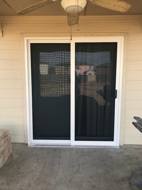 A sliding glass door with a ceiling fan hanging from the ceiling.