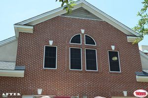 A brick building with three windows and a roof.