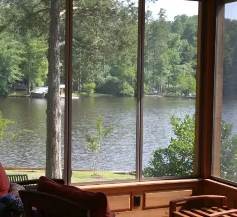 A screened in porch with a view of a lake