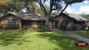 A brick house with a tree in front of it.