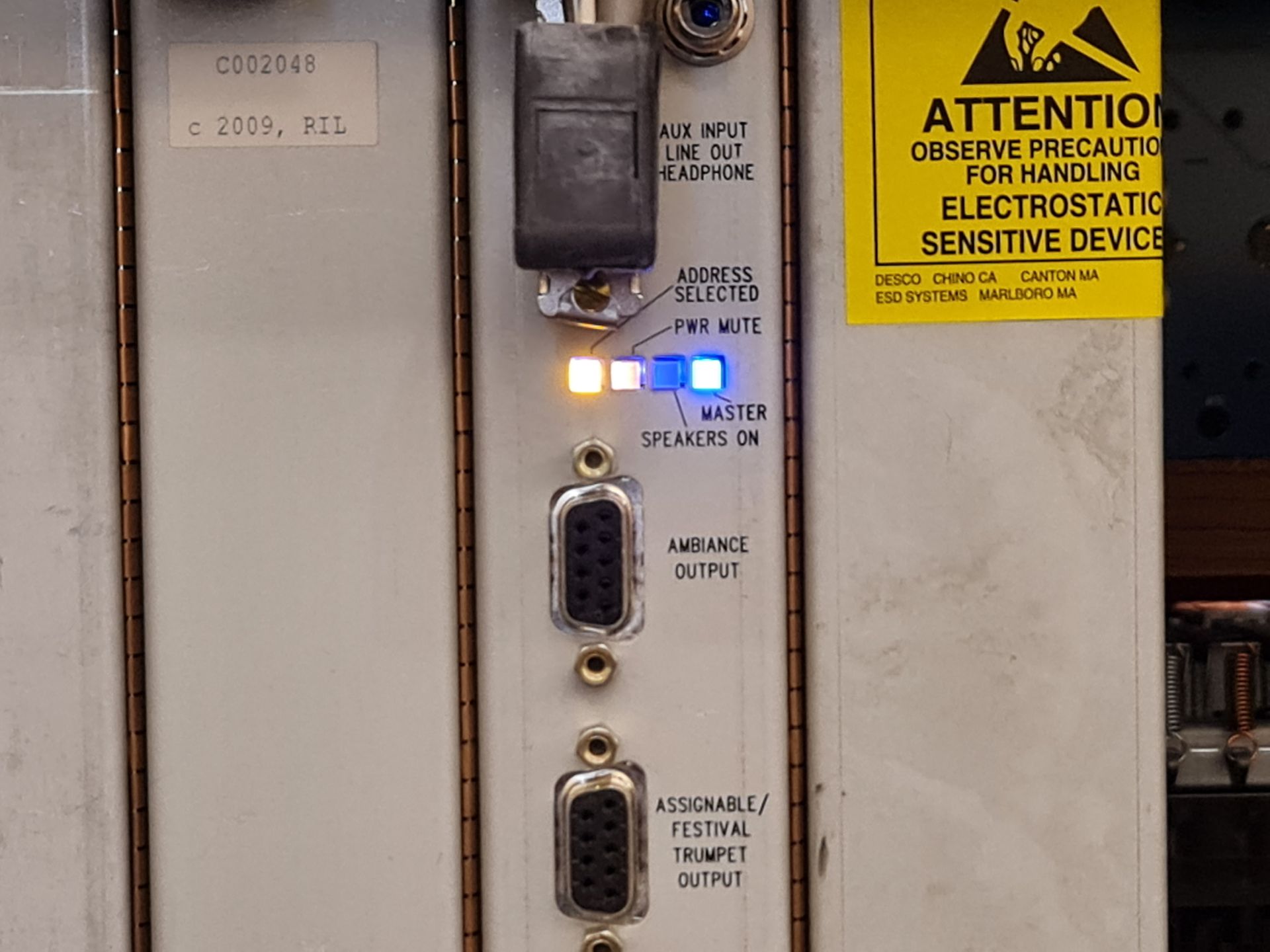 Panel with connectors and indicator lights, including an orange and a blue illuminated light.