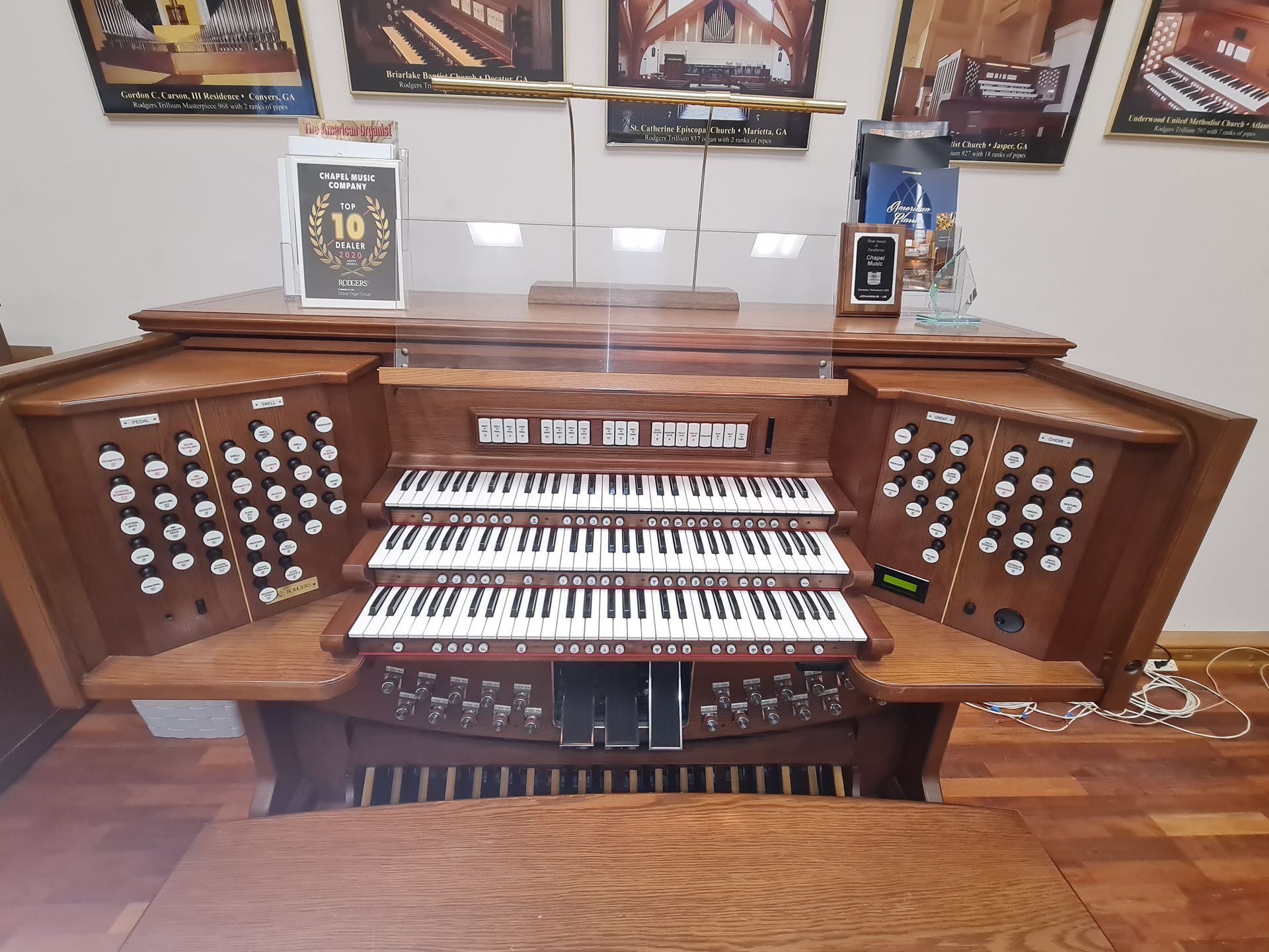 Hands playing a piano, lit by warm light; keys in focus, red seat.