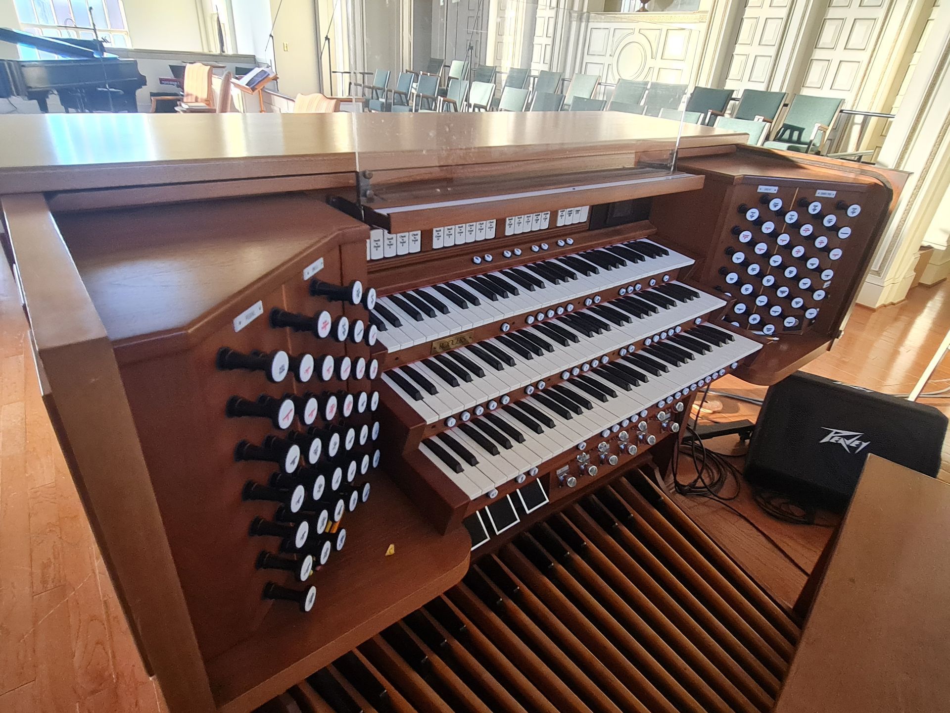 A person's hands adjusting the internal mechanics of a piano, showing keys and hammers.