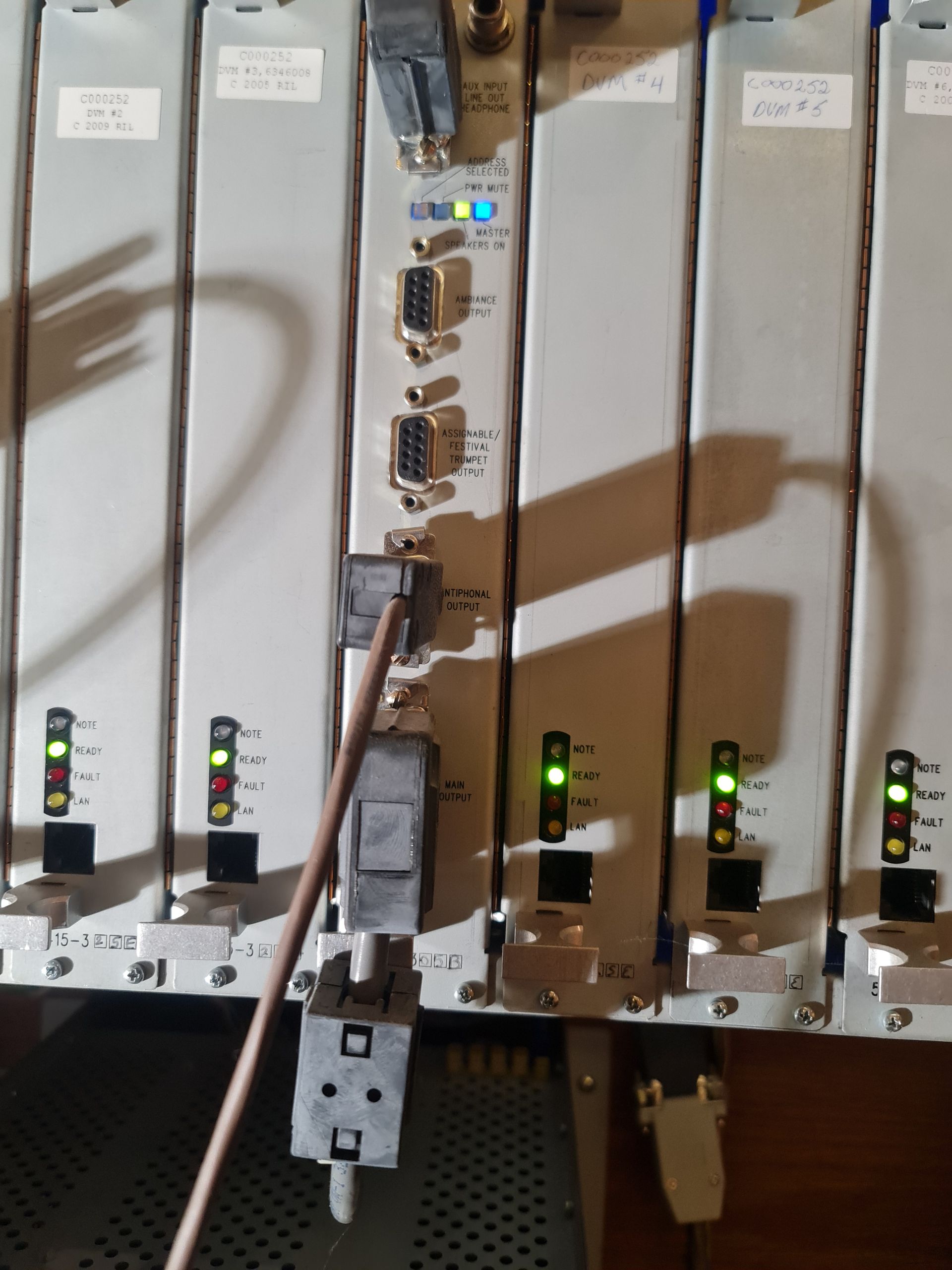 Rack of gray server modules with multiple ports and lights, with a pointer.