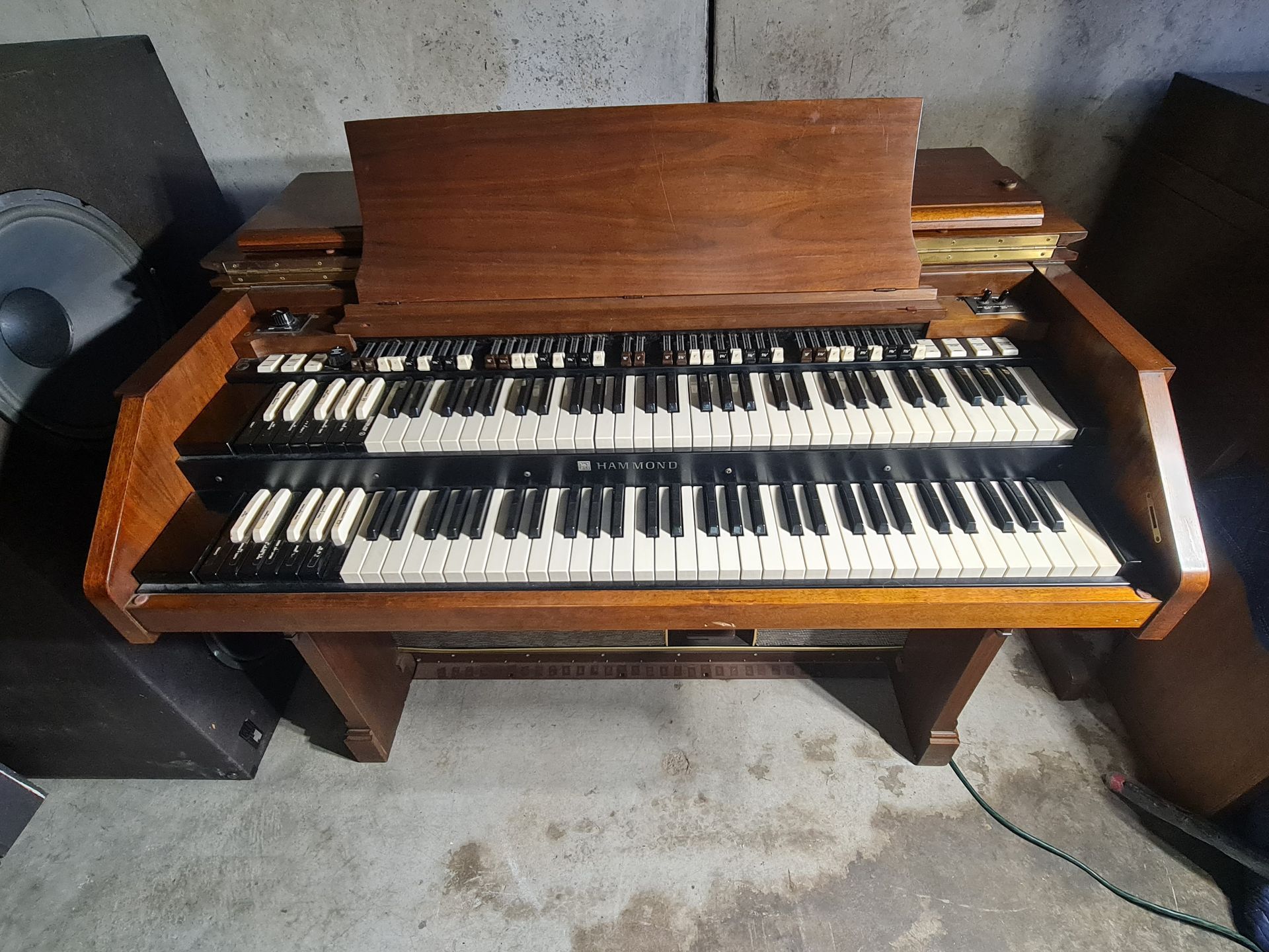 Person working on the inside of a piano, using tools. Hands close-up on hammers and strings.