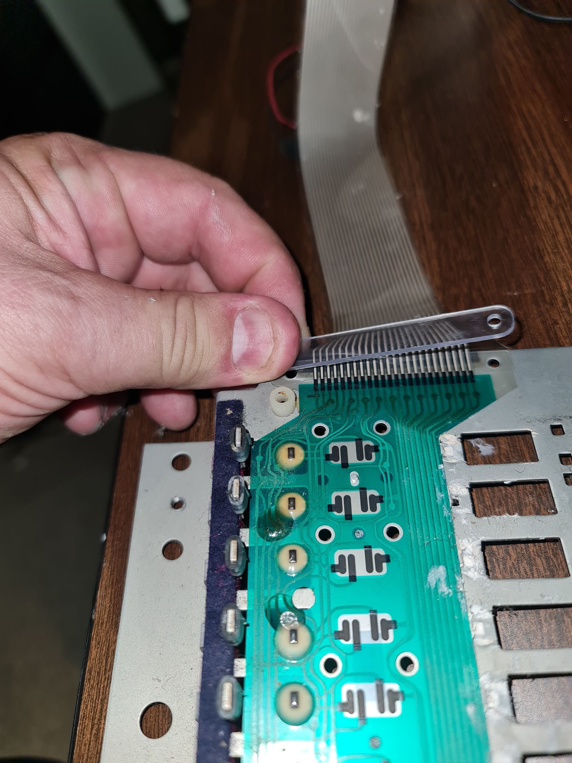 Hands playing a piano, fingers pressing keys; warm light.