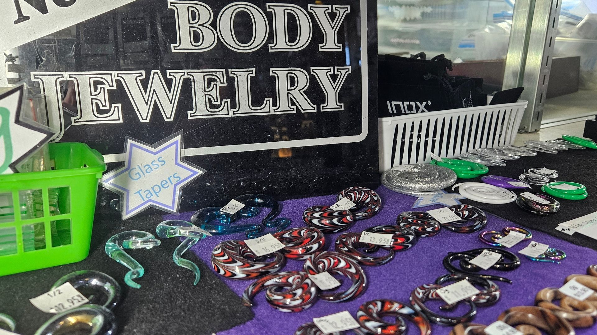 Body jewelry on display featuring glass, acrylic and wood tapers of various size.