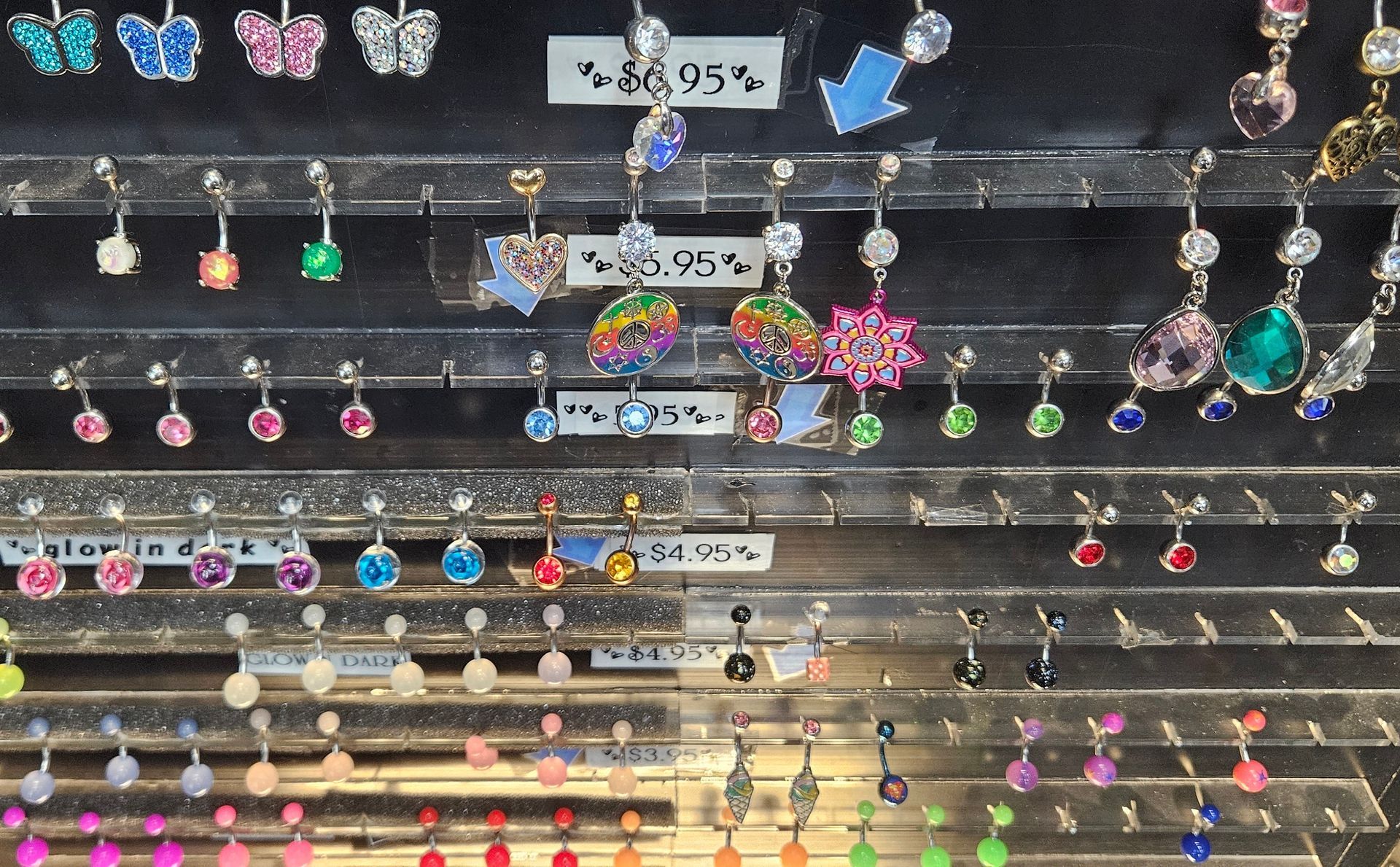 A look into the jewelry case displaying a colorful and shinny variety of body jewelry.