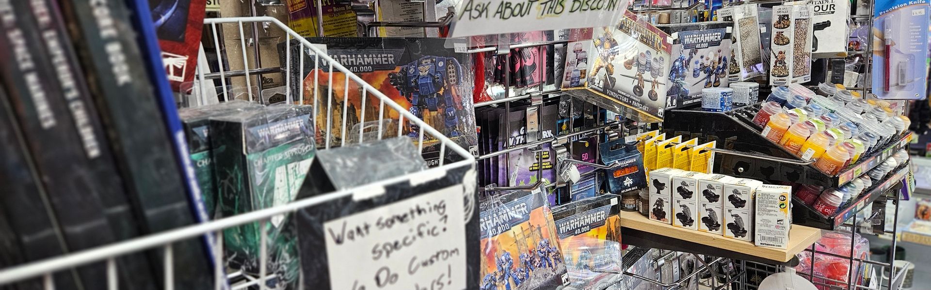 A close up image of a Warhammer display with codex, paints and tools.