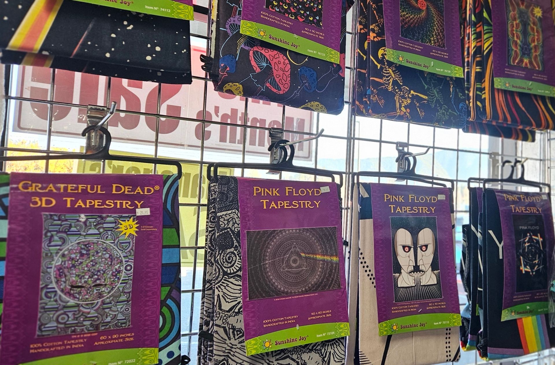 A display of colorful tapestries with psychedelic designs and bands.