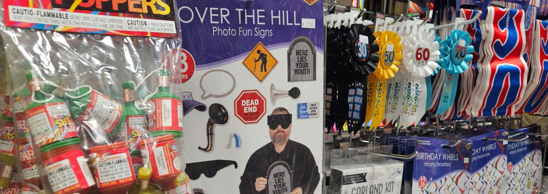 A close up image of several Over the Hill novelty gifts including ribbons, party poppers and a fun photo kit.