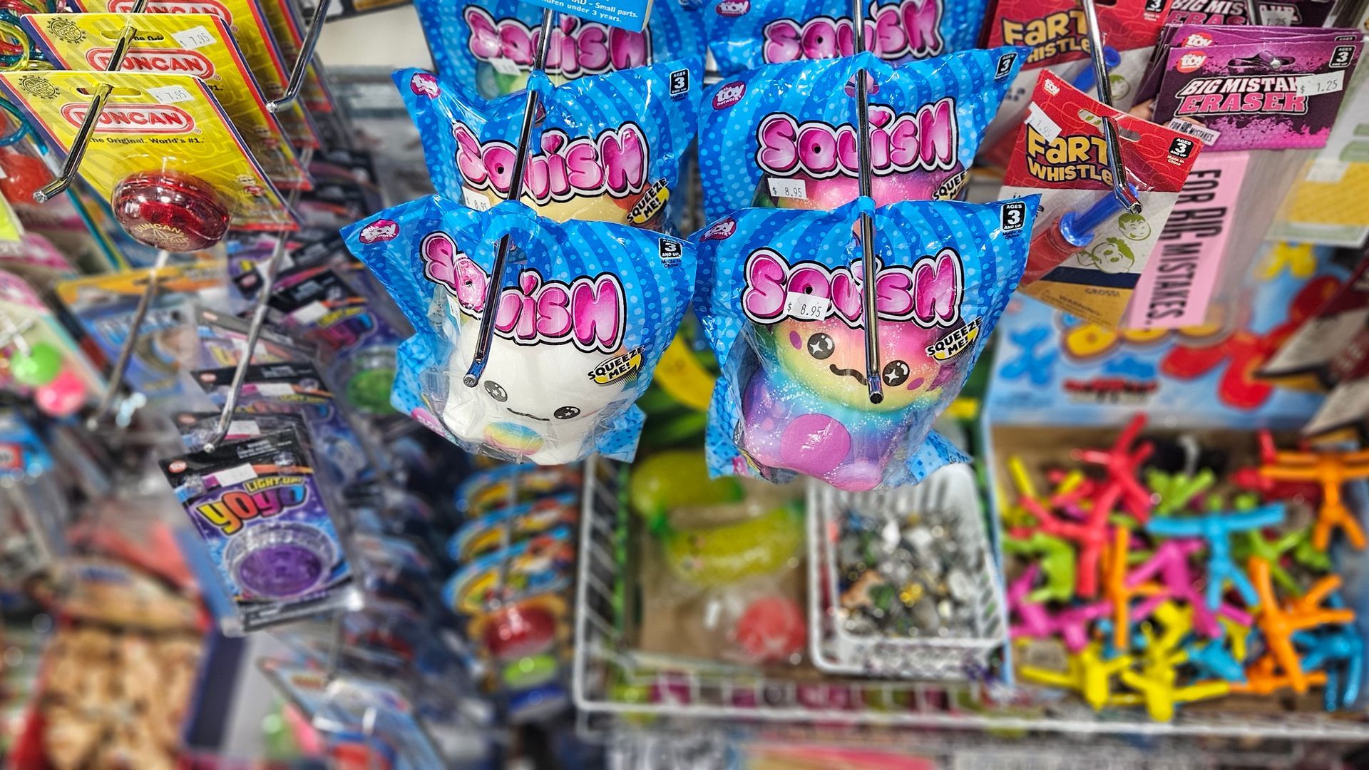 A image of kids novelty toys like yoyos, jacks, dolls and wooden puzzles.