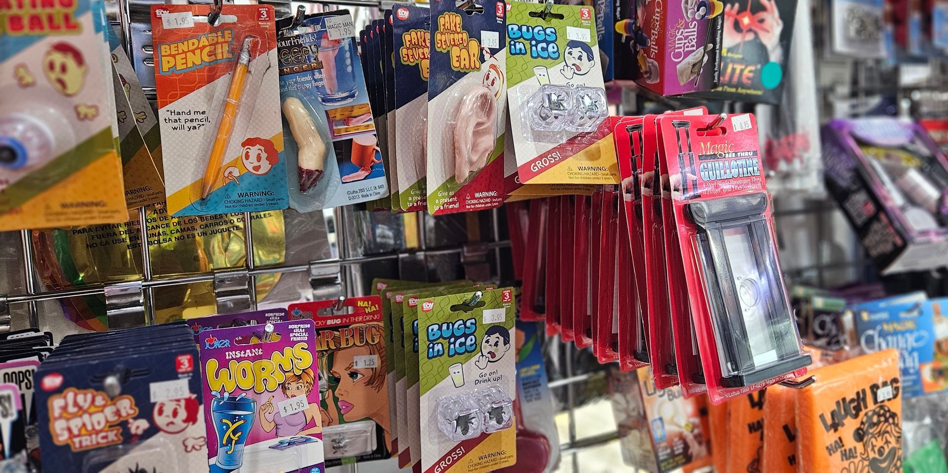 A close up image of a rack loaded with gags, toys and magic tricks.