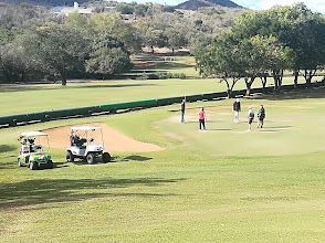 A group of people are playing golf on a golf course.