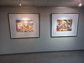 Two paintings are hanging on a wall in a room.