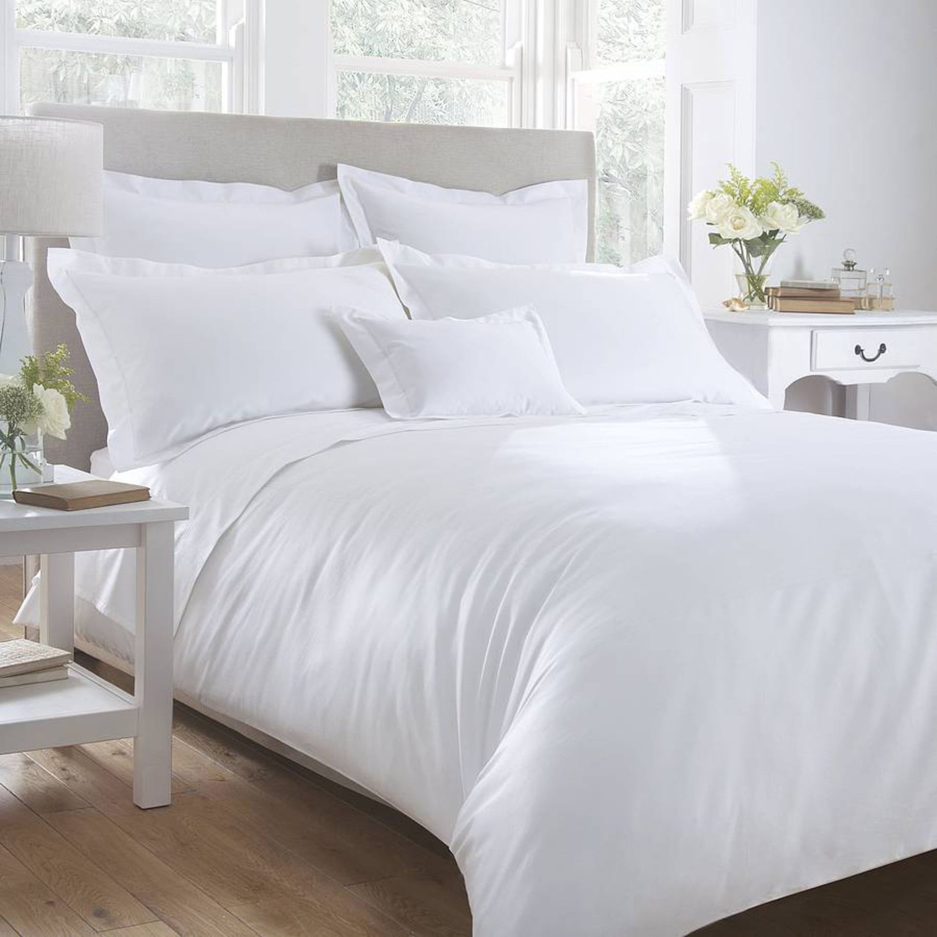 A bed with white sheets and pillows in a bedroom