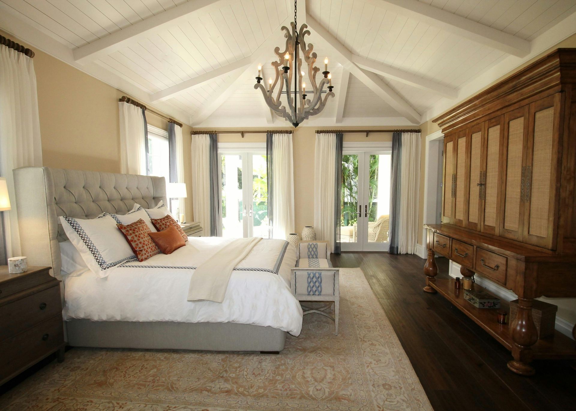 A bedroom with a large bed and a chandelier