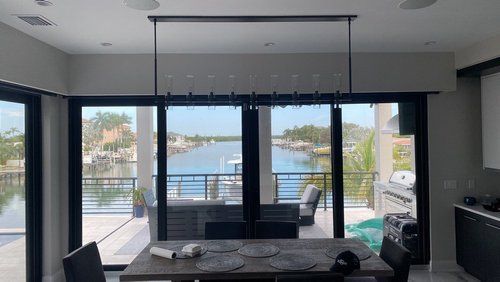 A dining room with a table and chairs and a view of the water.