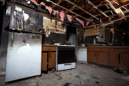 A kitchen in an abandoned house with a stove and refrigerator