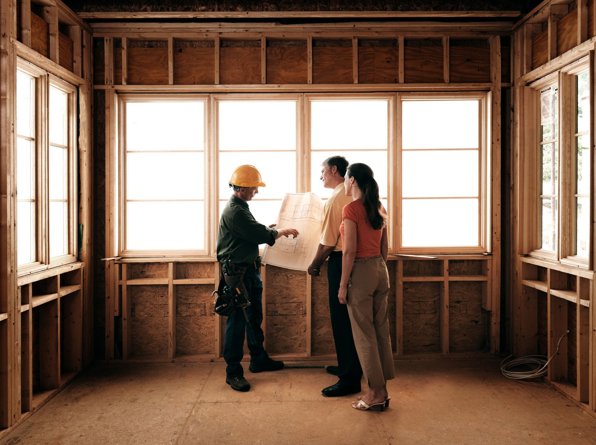 A couple consulting with an architect inside a home under renovation.