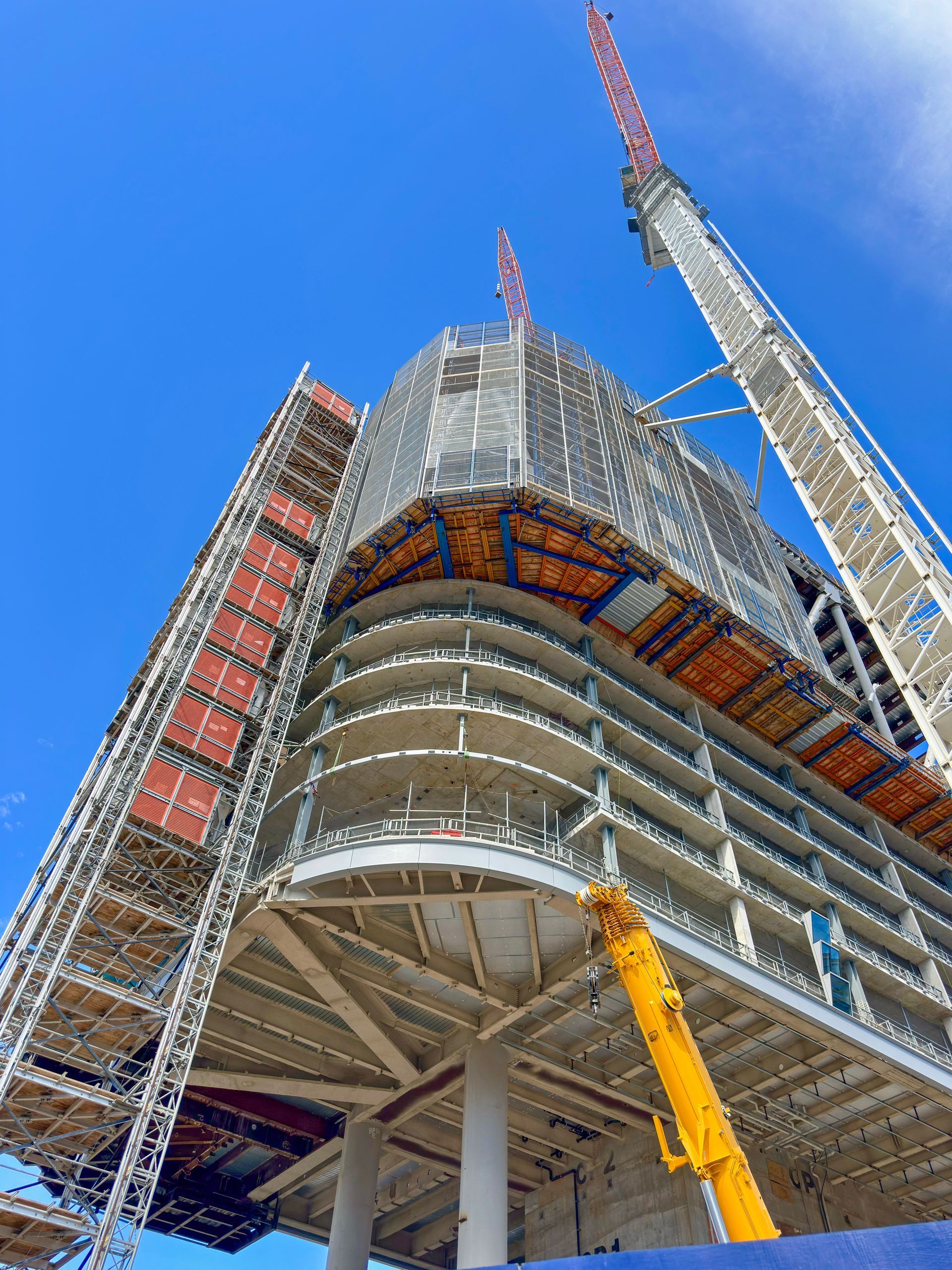 Bathroom with black and white patterned floor tiles, a toilet, vanity, shower, and artwork.