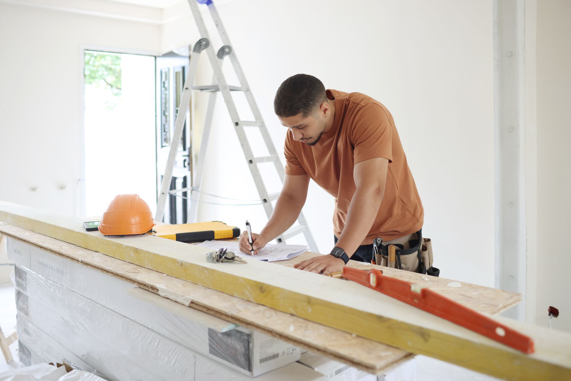 A home renovation contractor studying plans while working on a house construction site