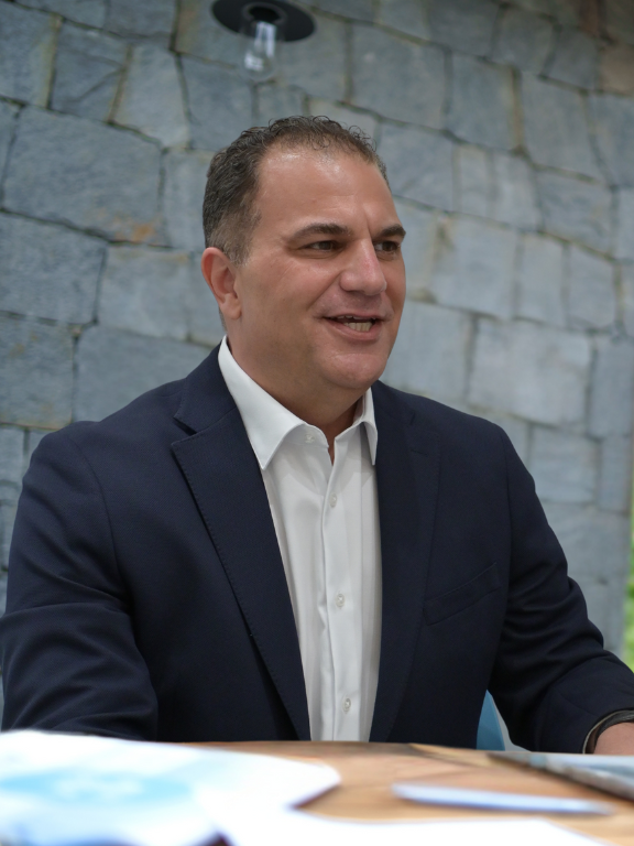 A man in a suit is giving a presentation to a group of people.
