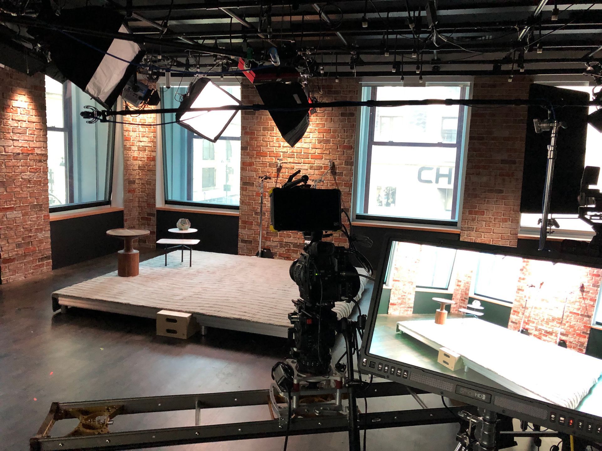 A studio with a table and chairs in front of a brick wall.