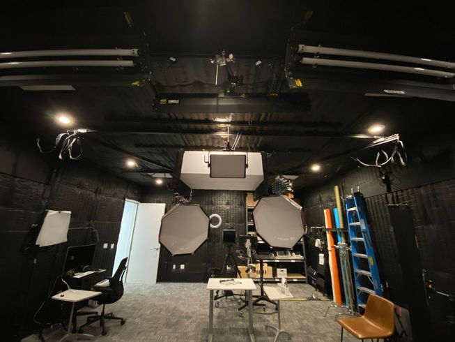 A dark room studio with lights on the ceiling.