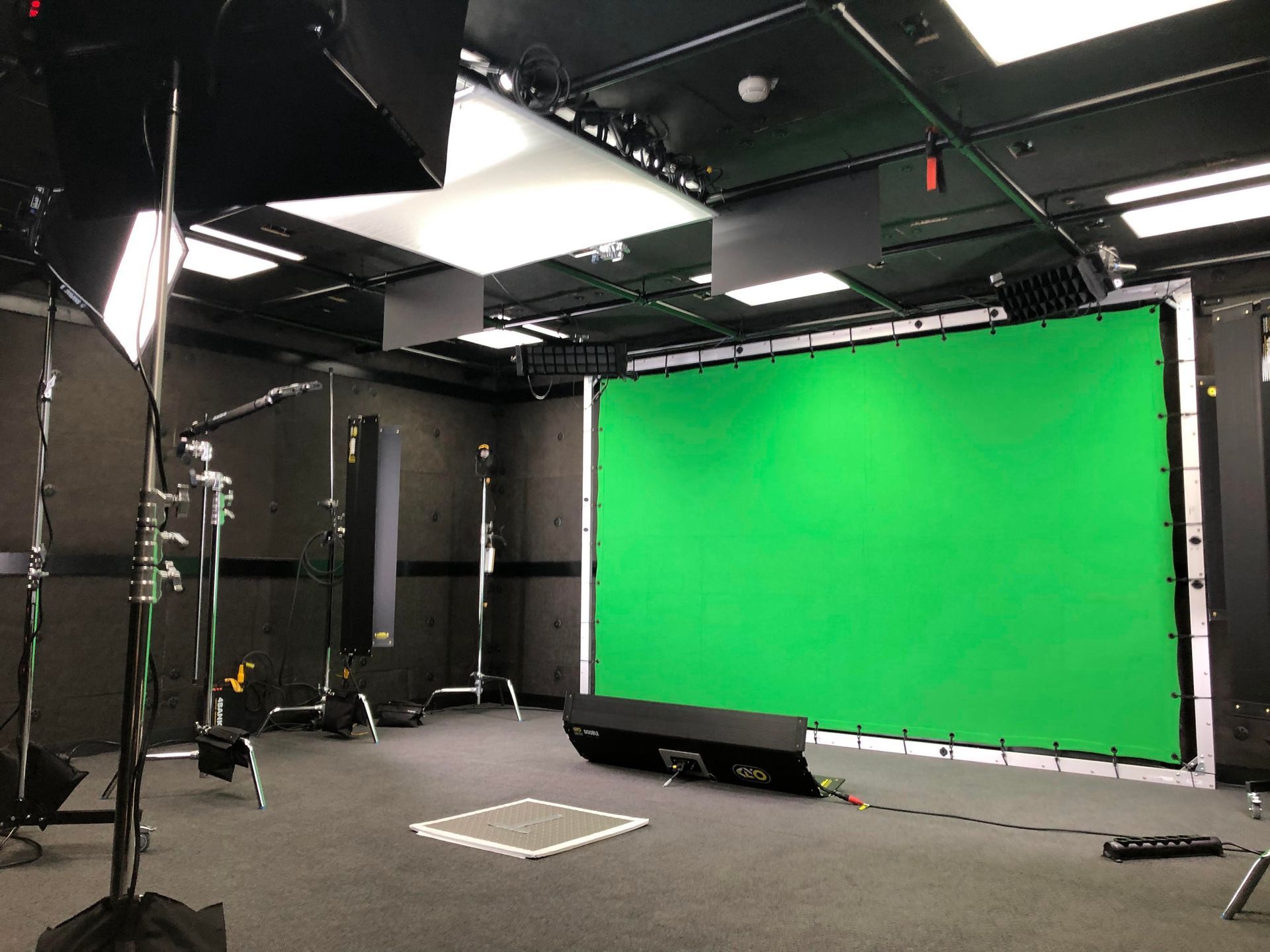 There is a green screen in the middle of the room.