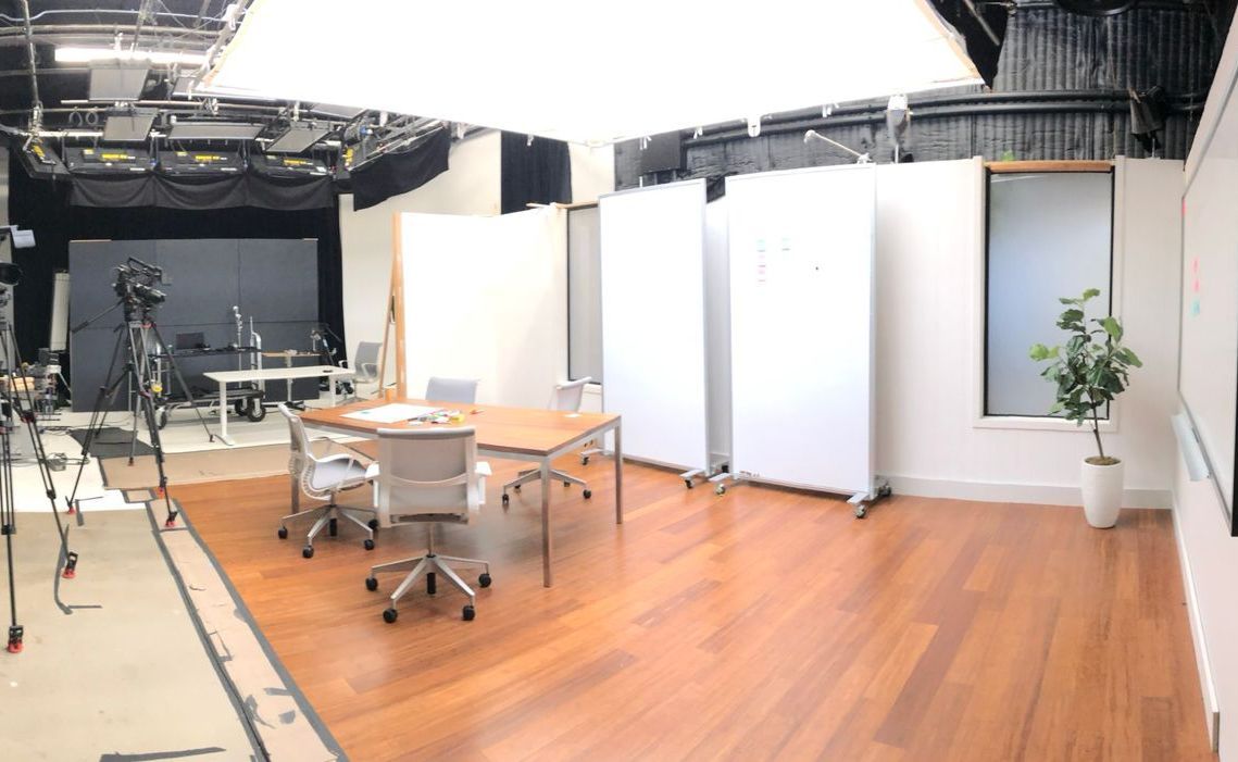 A large room with a wooden floor and a table and chairs in it.