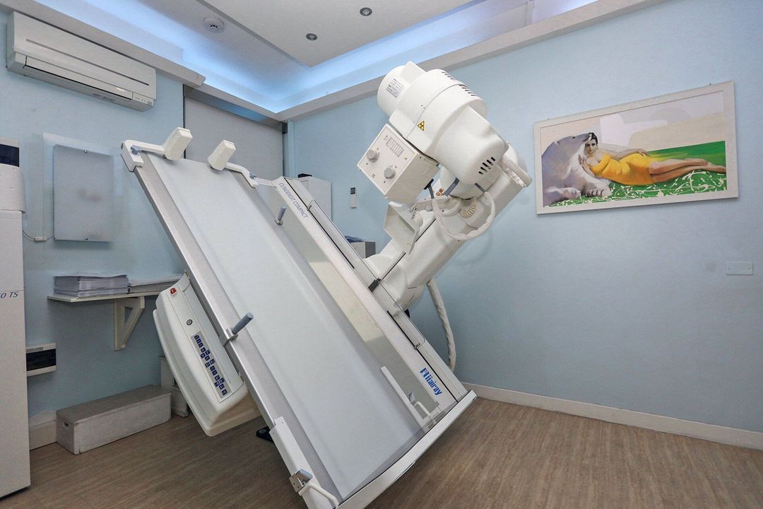 In un contesto clinico, un operatore sanitario esamina le mammografie e un'immagine ecografica digitale su un computer portatile.