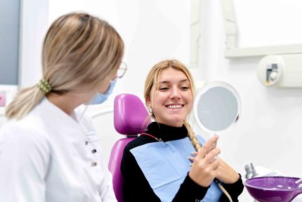 Woman Looking At Her Teeth After Treatment — Beatrice, NE — Pinkerton Dentistry