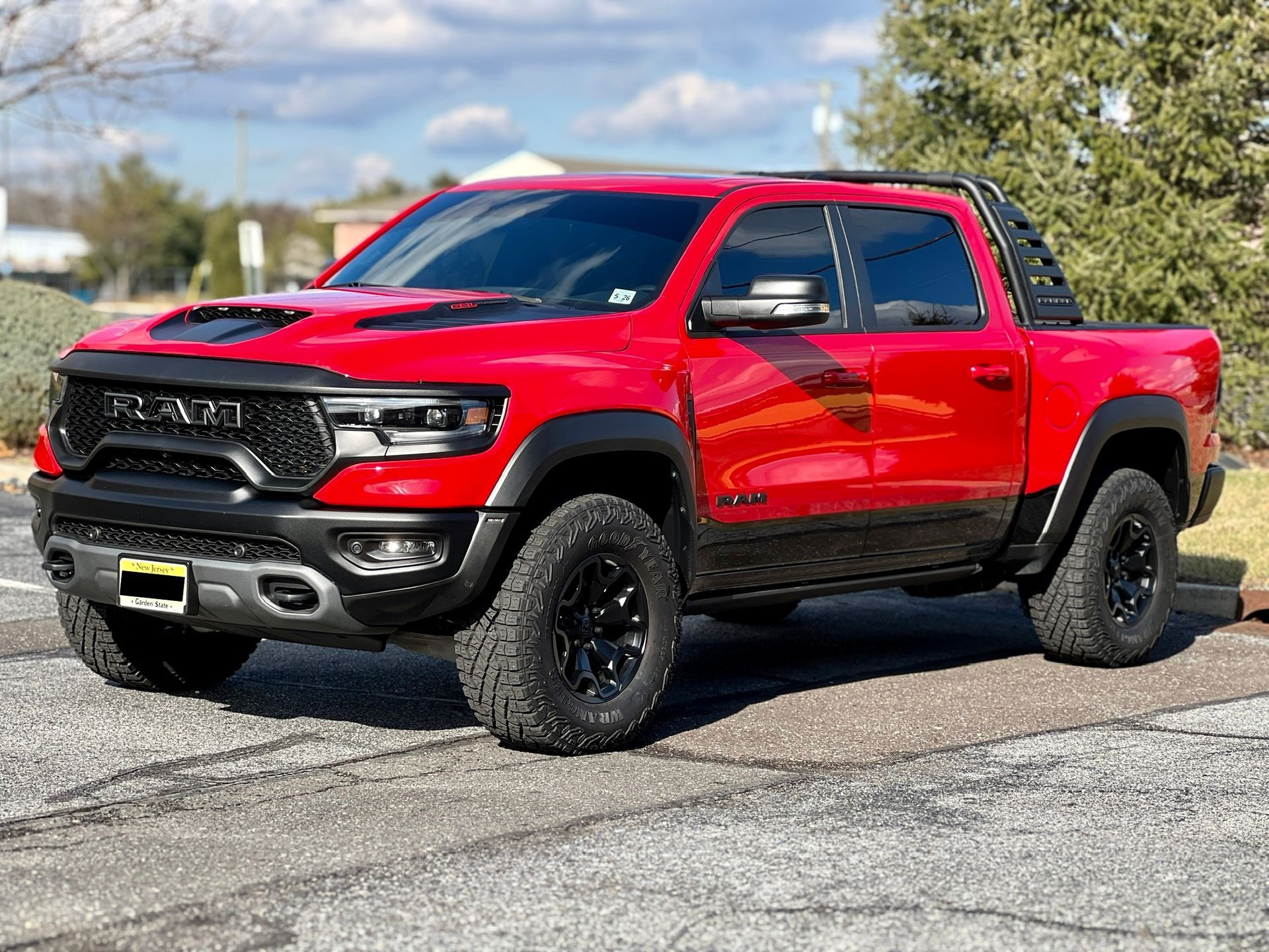 A red ram truck is parked on the side of the road.