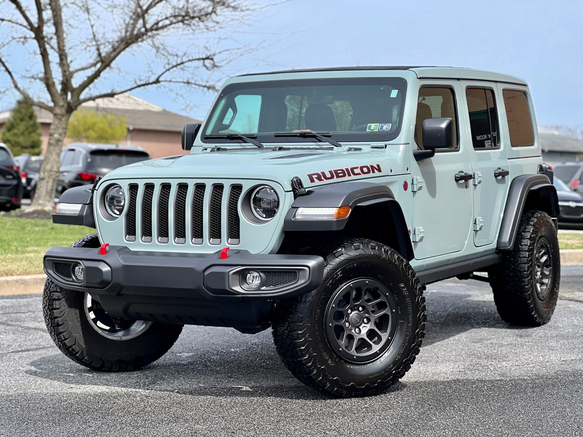A jeep wrangler is parked on the side of the road in a parking lot.