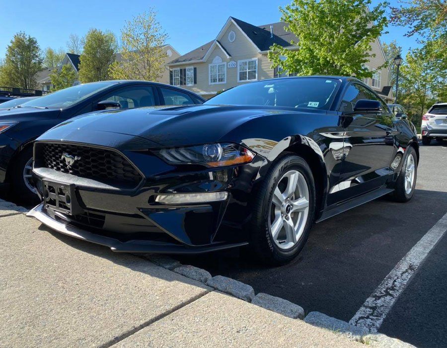 A black ford mustang is parked in a parking lot.