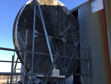 A large circular object is sitting in front of a building.