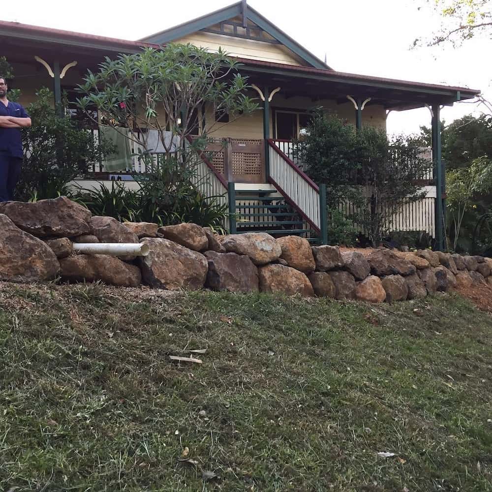 Rock Wall In Front Of Queenslander Home — Retaining Wall Builders in Tweed Heads, NSW