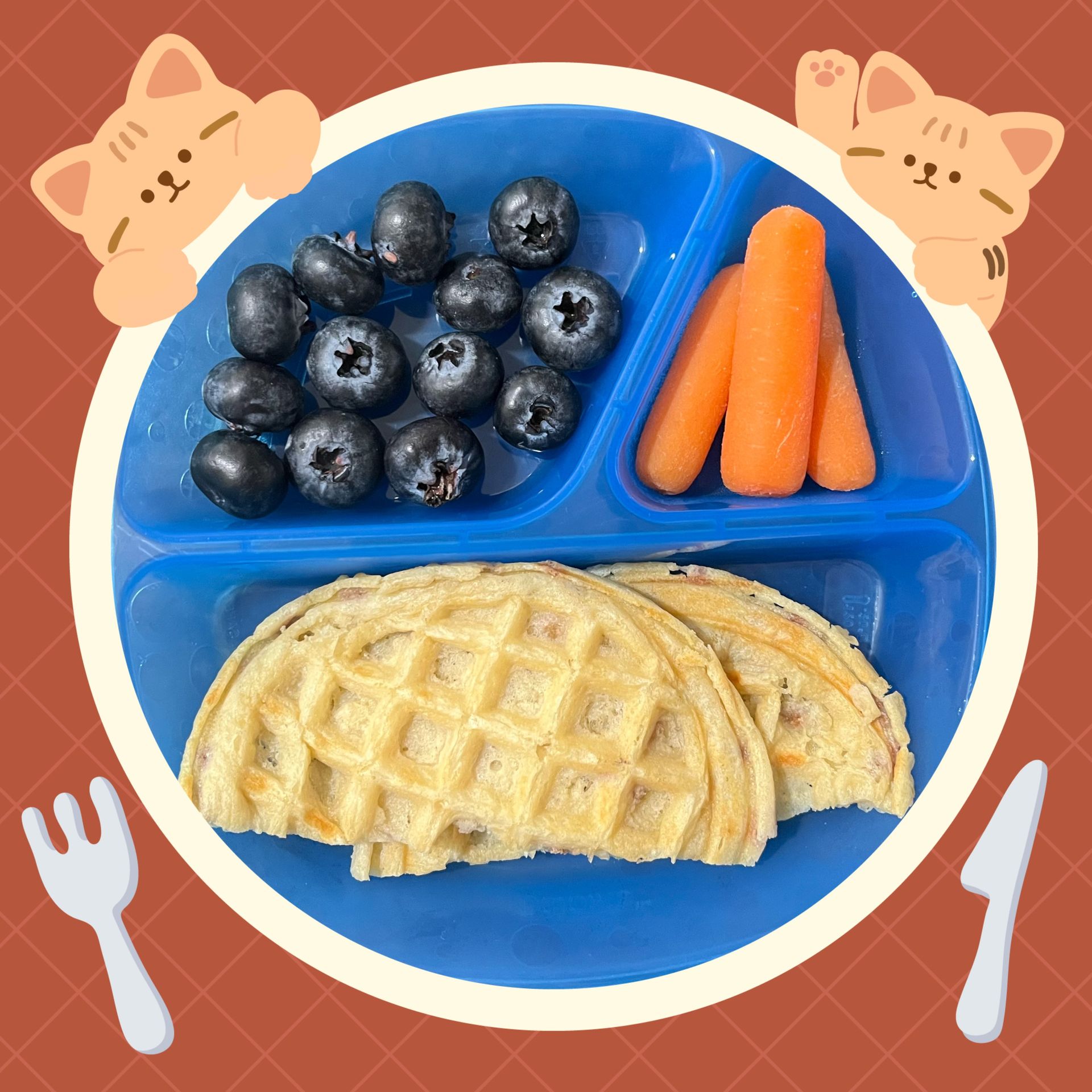 Blue plate with blueberries, carrots, and waffles, decorated with cartoon cats and cutlery.