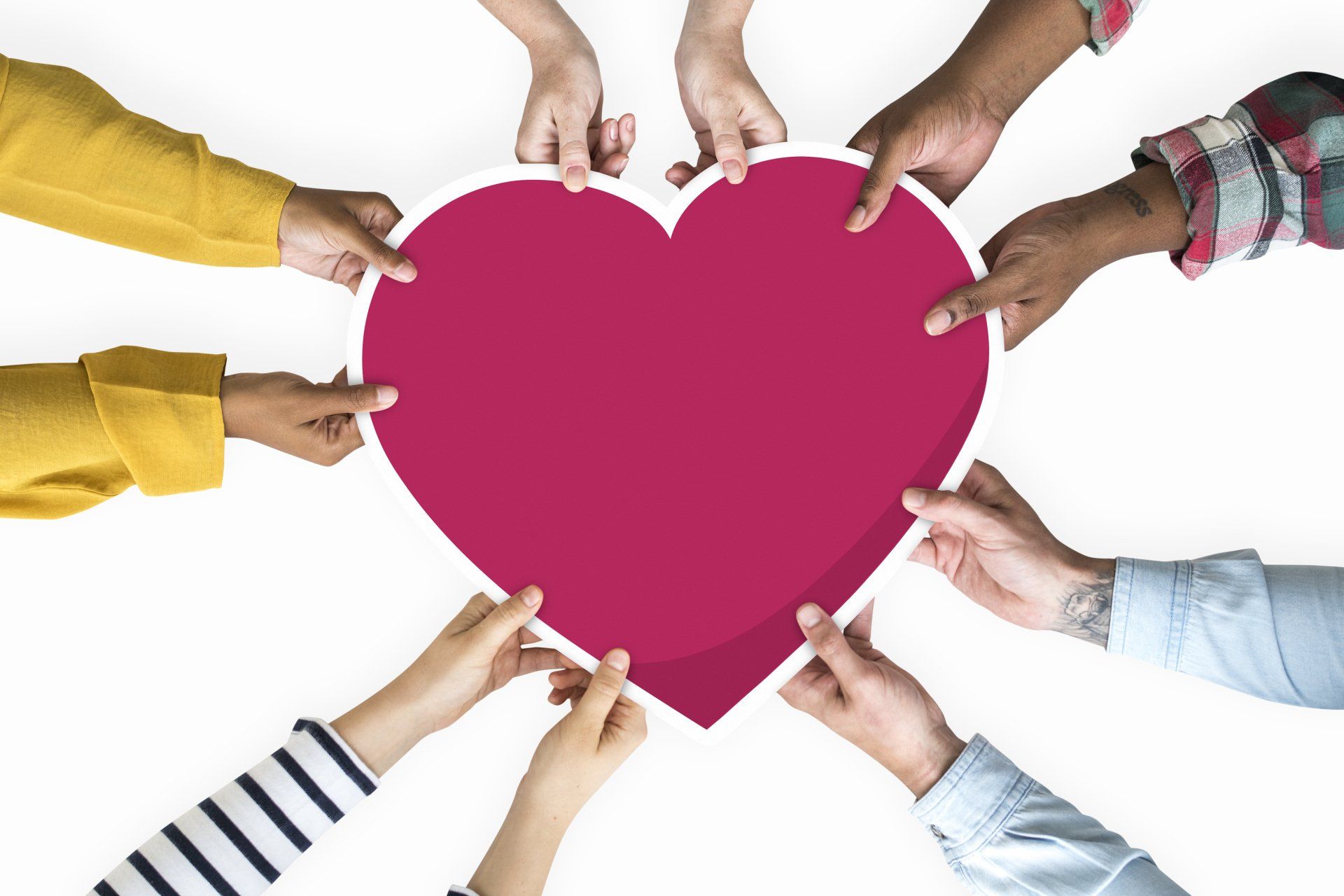 a group of people are holding a red heart in their hands .