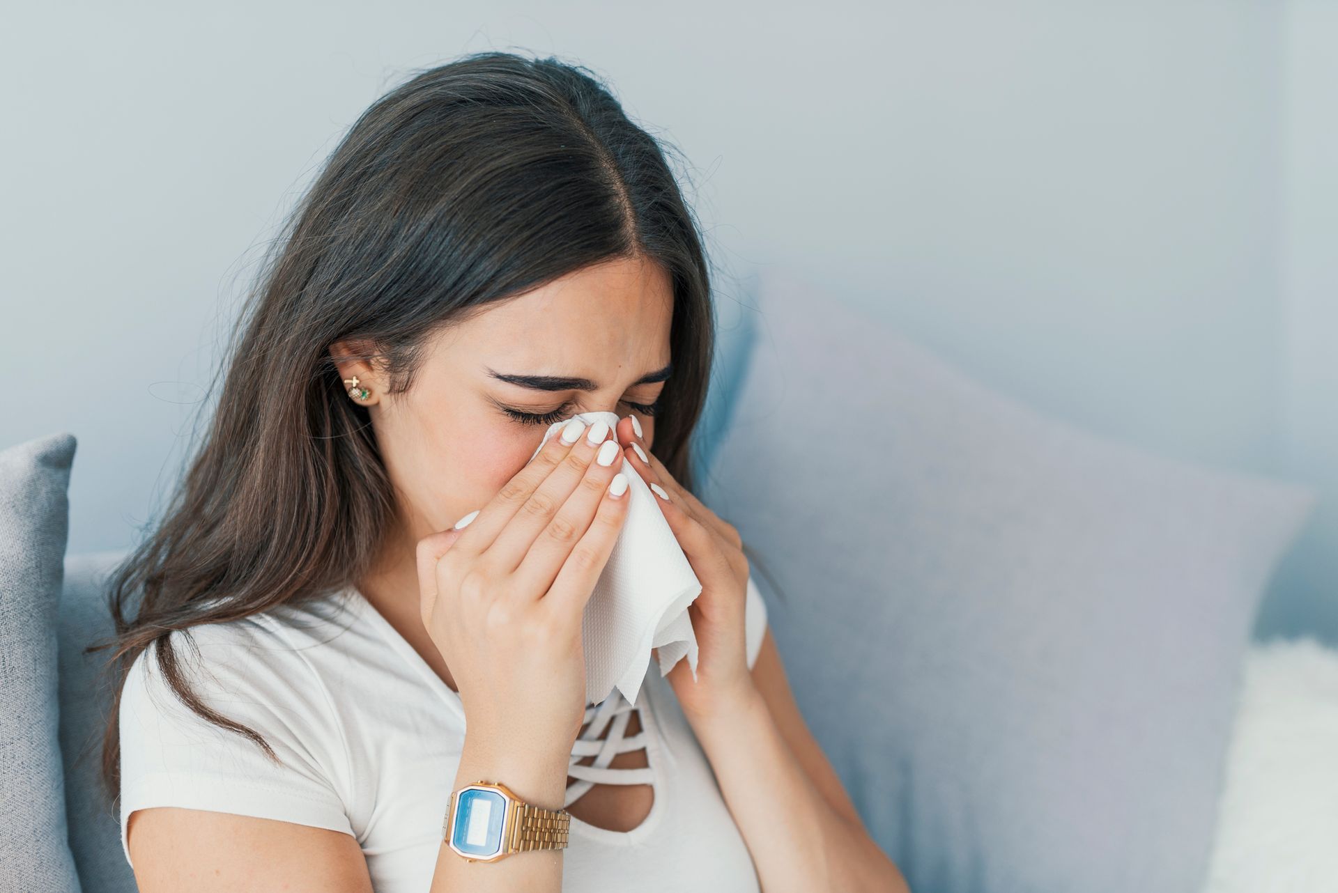 Woman sneezing due to allergies, highlighting the importance of allergy testing for relief and care.