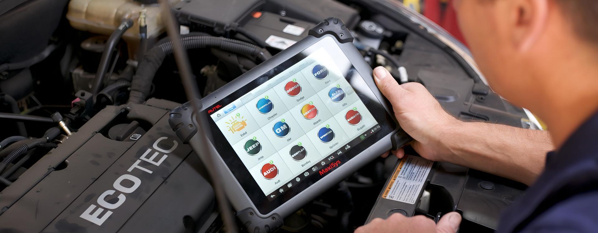 A Man is Using a Tablet to Check the Engine of a Car — CWC Auto Services In Ainslie, ACT