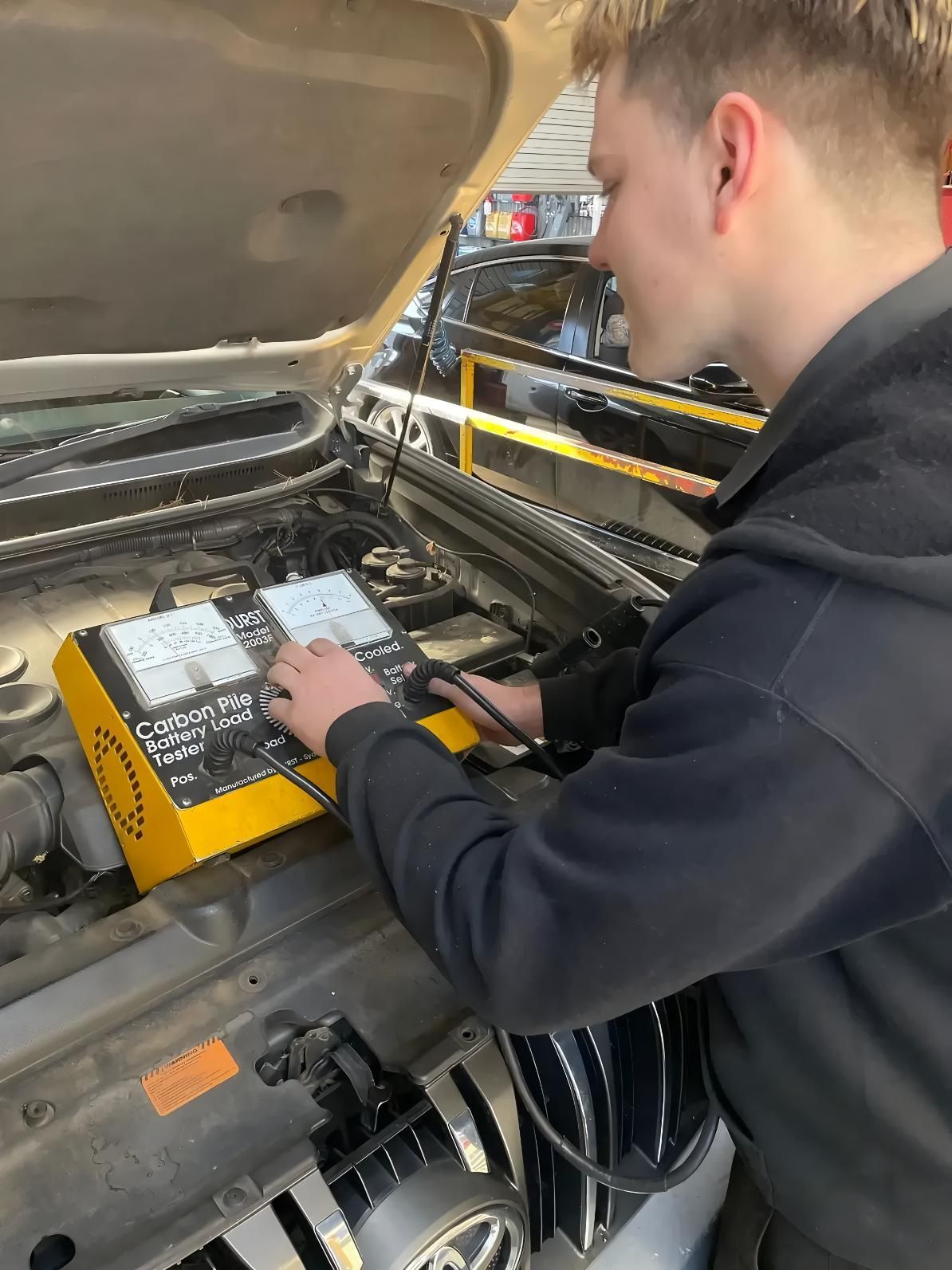 A Young Man is Working on the Engine of a Car — CWC Auto Services In Ainslie, ACT