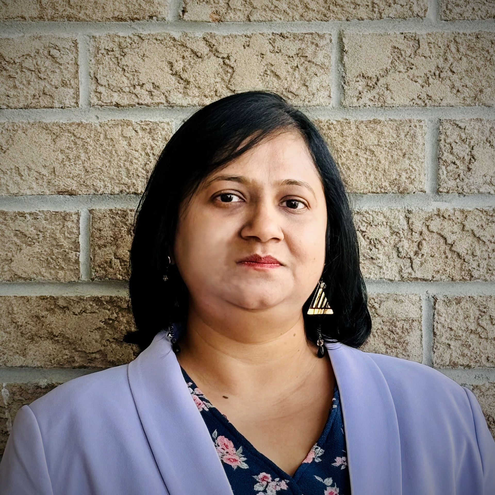 A living room with a couch and a wooden table with a vase of flowers on it.